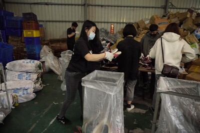 歐肯系統傢俱員工進行舊鞋分類裝袋作業 